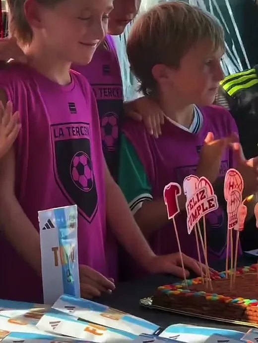 El cumpleañero soplando las velitas de la torta, rodeado de sus amigos