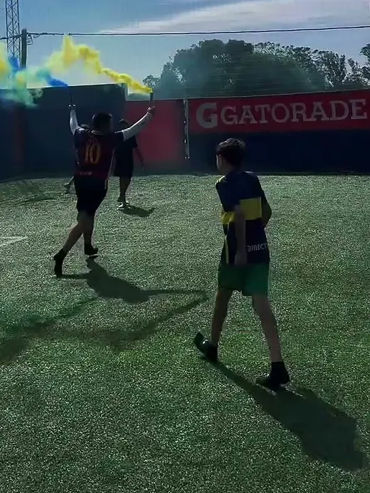 Chicos jugando mientras se levanta el humo amarillo de las bengalas